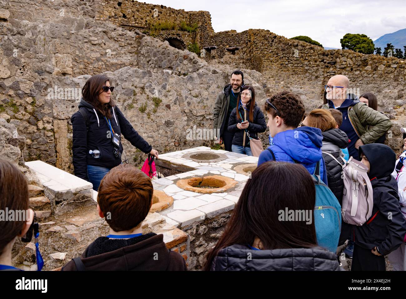 Pompeji Tourismus; ein Reiseleiter zeigt Touristen eine römische Weinbar, eine von vielen in der Stadt, aus dem 1. Jahrhundert n. Chr.; Pompeji Ruinen, Pompeji Italien Stockfoto