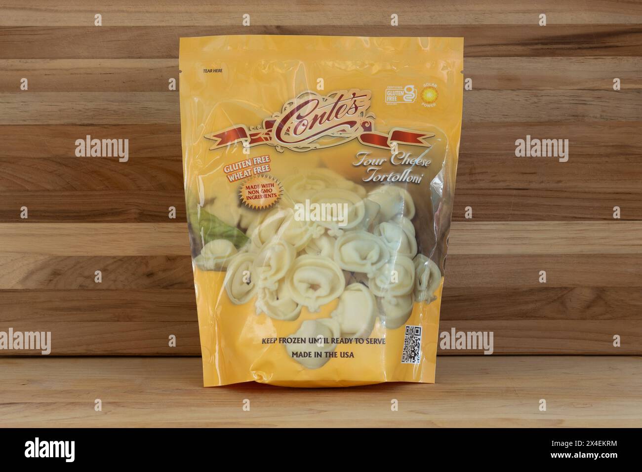 Paket mit gefrorenen glutenfreien vier Käse-Tortolloni der Marke Conte auf rustikalem Holzhintergrund mit Kopierraum Stockfoto