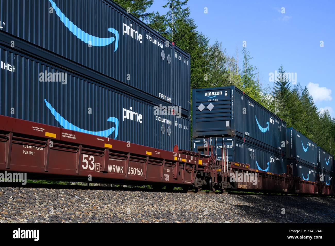 Skykomish, WA, USA - 1. Mai 2024; Amazon Prime Interm-Frachtcontainer im intermodalen Zug mit Namen und Logo der Marke Smile unter blauem Himmel Stockfoto