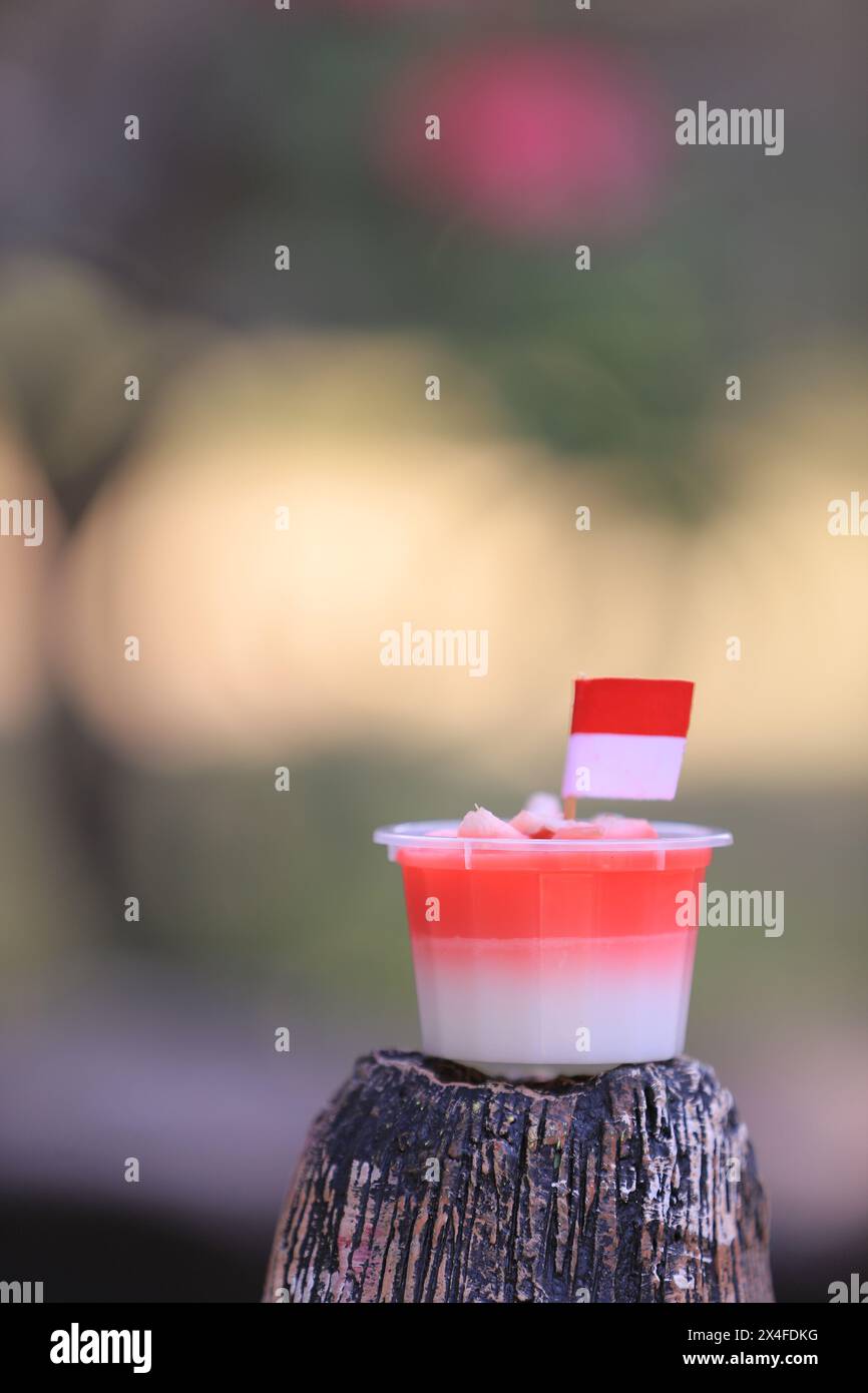 Rot-weißer Pudding mit einer kleinen indonesischen Flagge. Unscharfer Hintergrund. Stockfoto