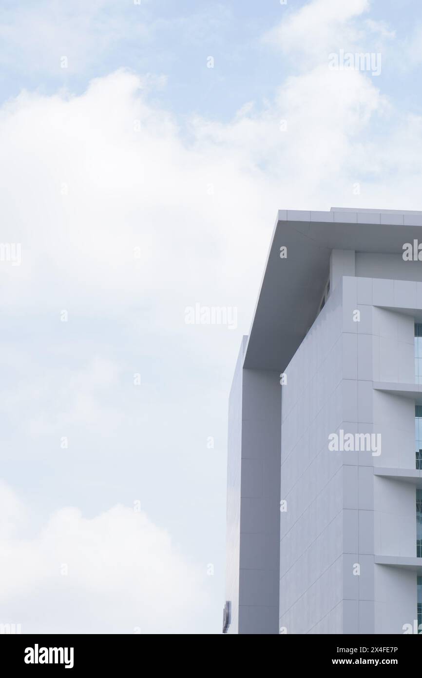 Ein mehrstöckiges minimalistisches Gebäude mit einem karierten Muster und Glas auf jeder Ebene und einem klaren Himmel Stockfoto
