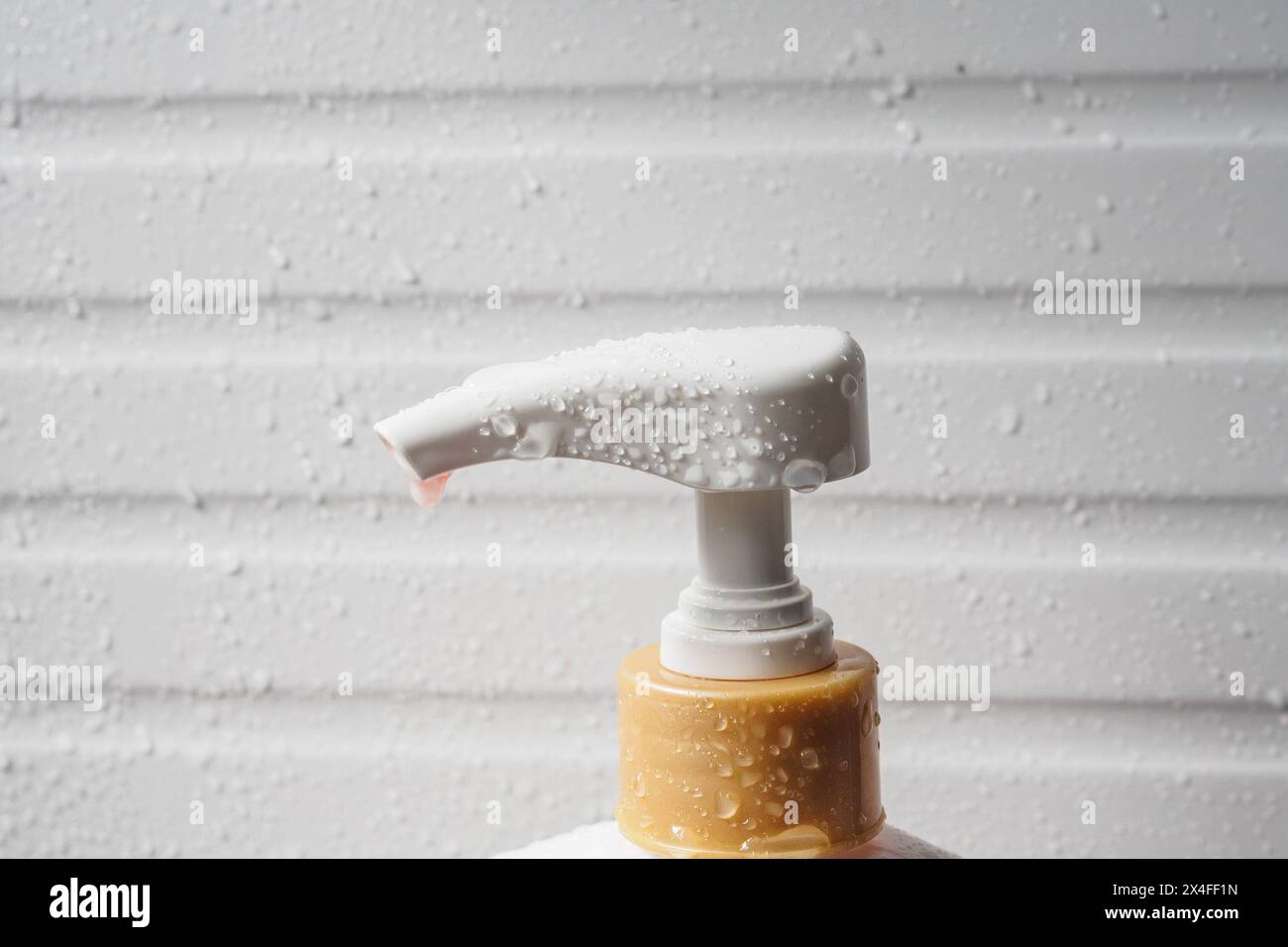 Wassertropfen auf die Flüssigseifenspenderpumpe während der Badzeit Stockfoto
