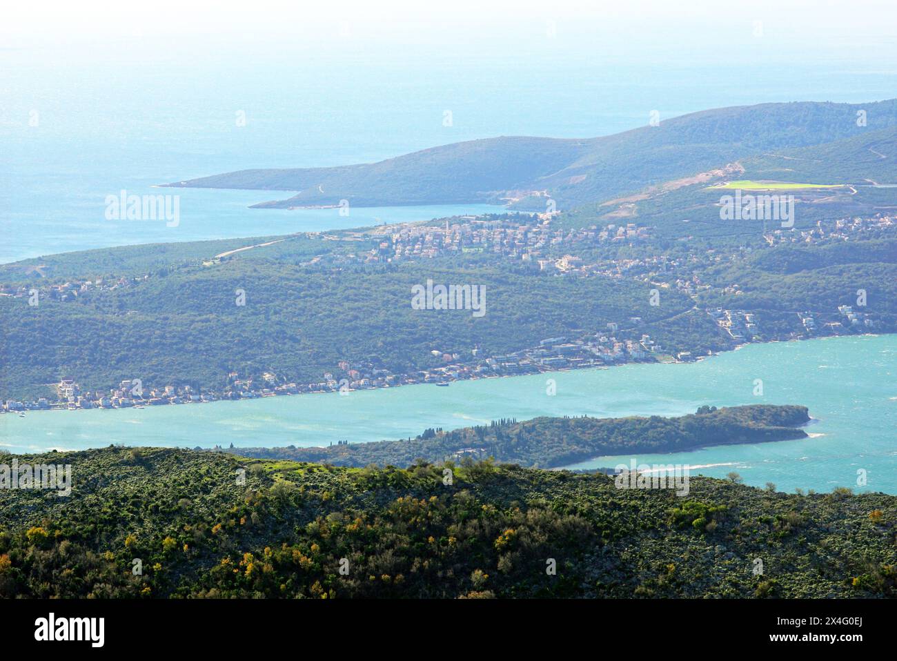 Blick von oben auf ein Fragment der montenegrinischen Halbinsel Lustica mit Traste Bay und der größten Insel in der Bucht von Kotor (St. Mark) Stockfoto