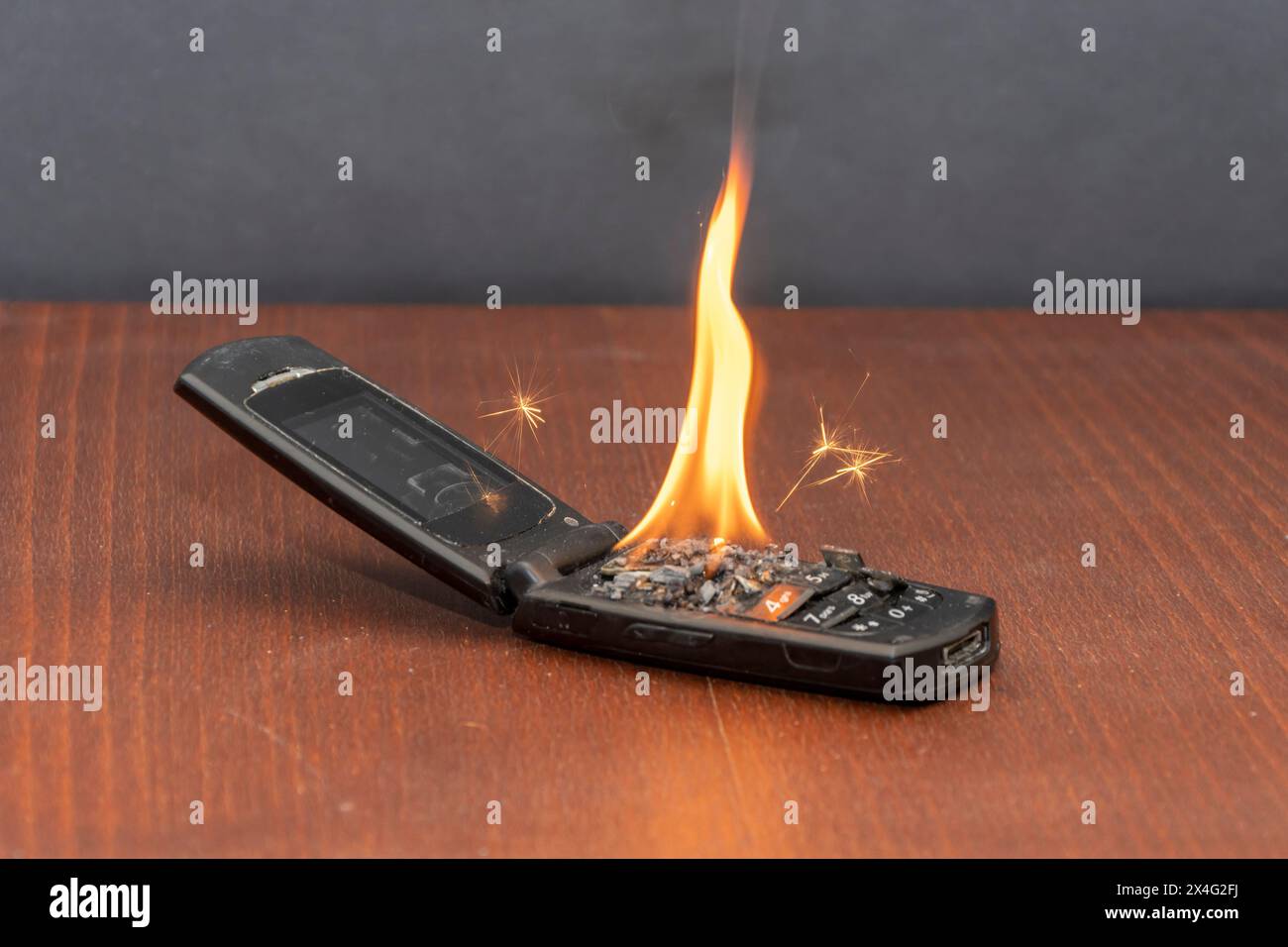 Feuer eines alten Mobiltelefons, Batterieoxidation. Die Ursache des Feuers in der Wohnung, ein Kurzschluss. Stockfoto