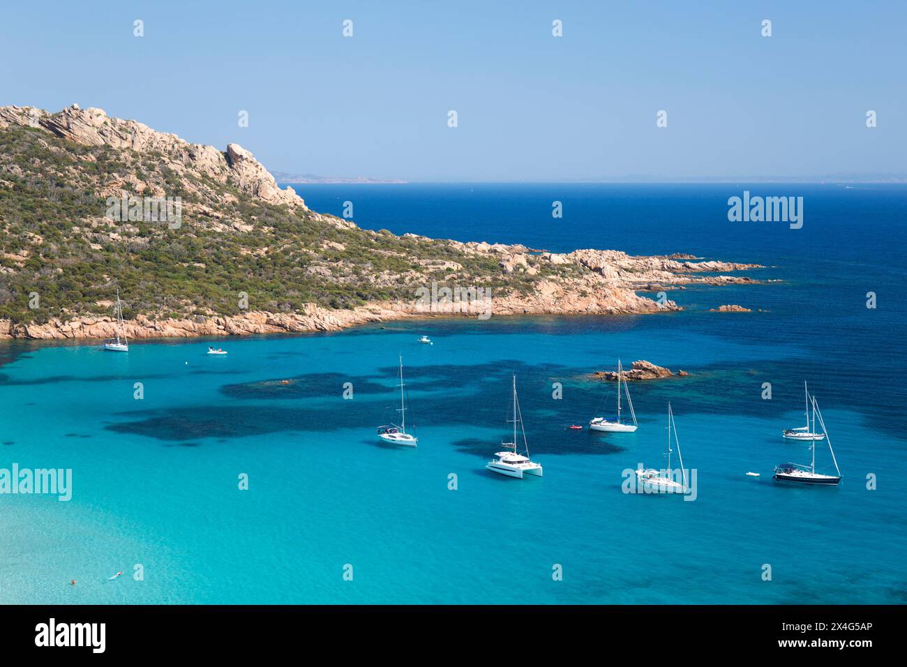 Sartène, Corse-du-Sud, Korsika, Frankreich. Blick auf das türkisfarbene Wasser der Cala di Roccapina, Yachten vor Anker in der Bucht. Stockfoto