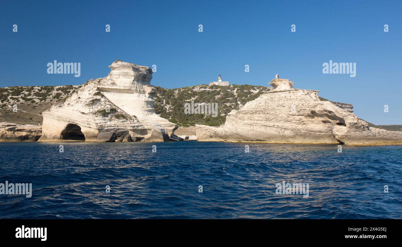 Bonifacio, Corse-du-Sud, Korsika, Frankreich. Blick vom Meer auf den Leuchtturm und die zerklüfteten Kalksteinklippen von Capo Pertusato. Stockfoto