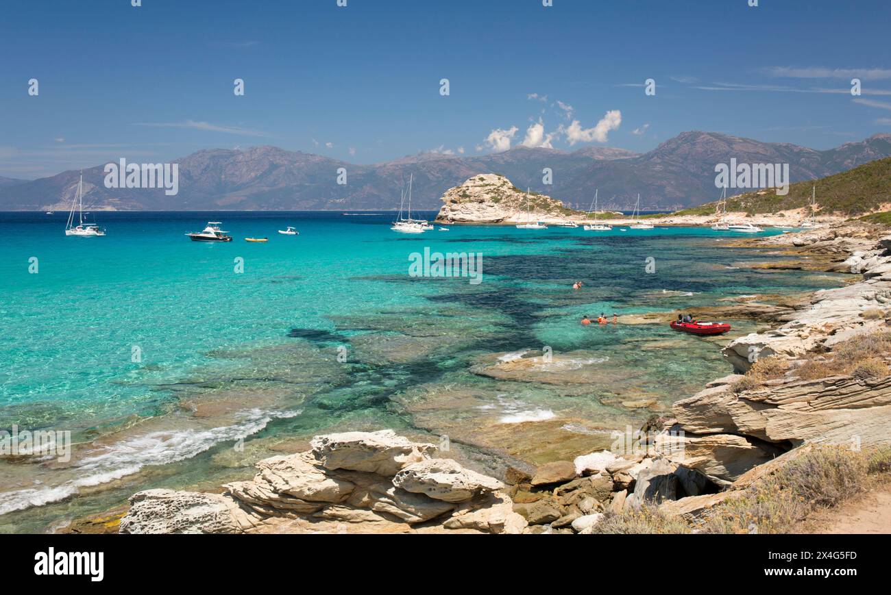 Saint-Florent, Haute-Corse, Korsika, Frankreich. Blick über klares türkisfarbenes Wasser auf die Halbinsel Cap Corse von der felsigen Küste in der Nähe der Plage du Loto. Stockfoto