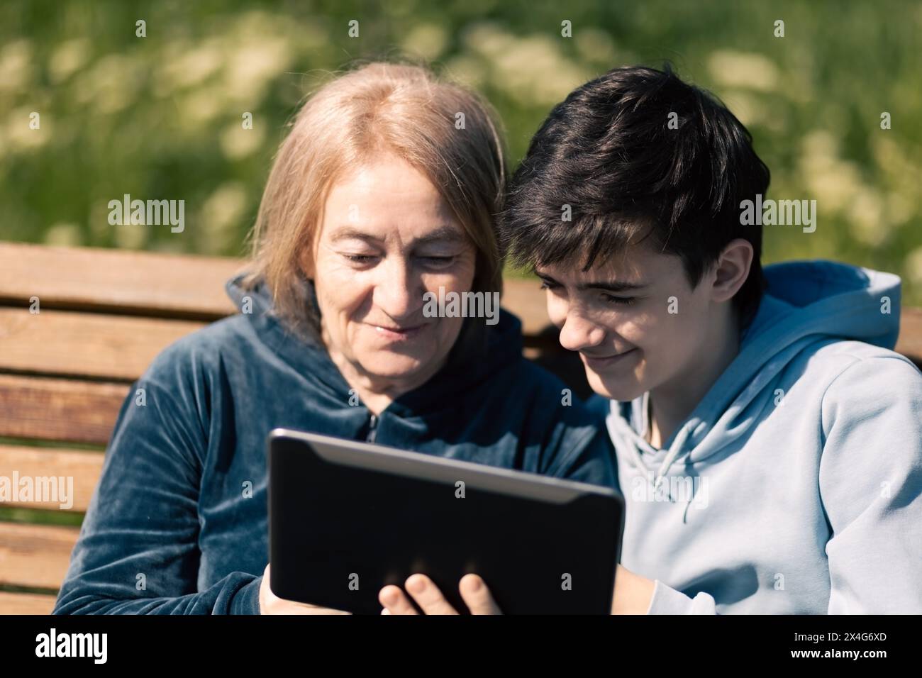Eine ältere Frau mit ihrem Enkel, die moderne Technologie nutzt Stockfoto