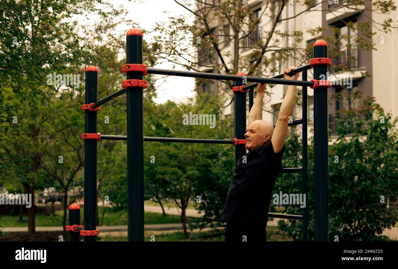 Senior Mann, der Sport auf Fitness-Outdoor-Trainingsstationen macht Stockfoto