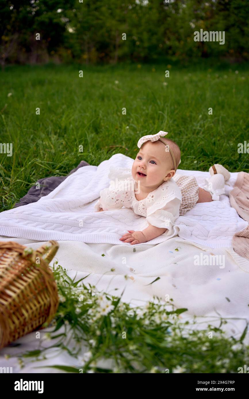 Ein kleines Mädchen kriecht beim Picknick auf der Decke Stockfoto