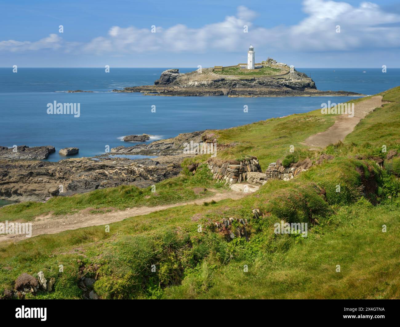 Der South West Coast Path führt am Godrevy Lighthouse vorbei, einem bekannten Wahrzeichen an der Küste Cornwalls. Stockfoto