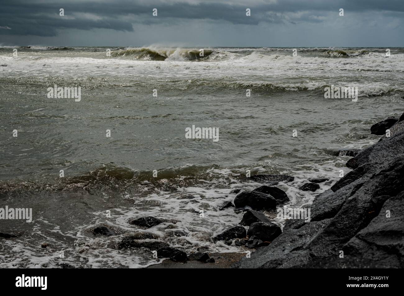 Das Tyrrhenische Meer, Italien, eine stürmische Quelle mit schäumenden Wellen an einem Strand in der Nähe von Rom Stockfoto
