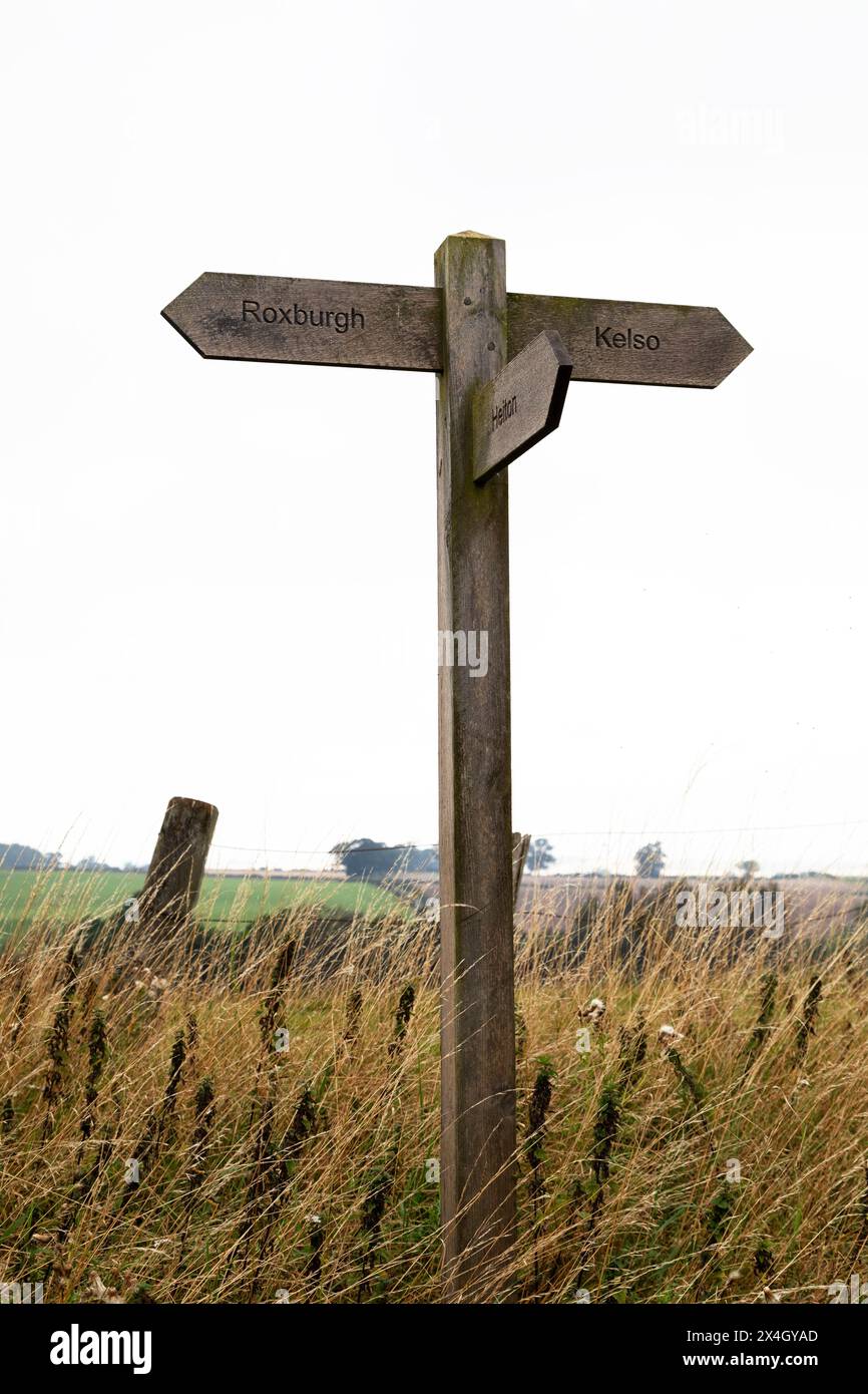 Schilder, die auf Wanderwege nach Roxburgh, Kelso und Heiton in der Region Scottish Borders zeigen. Das Schild ist aus Holz. Stockfoto
