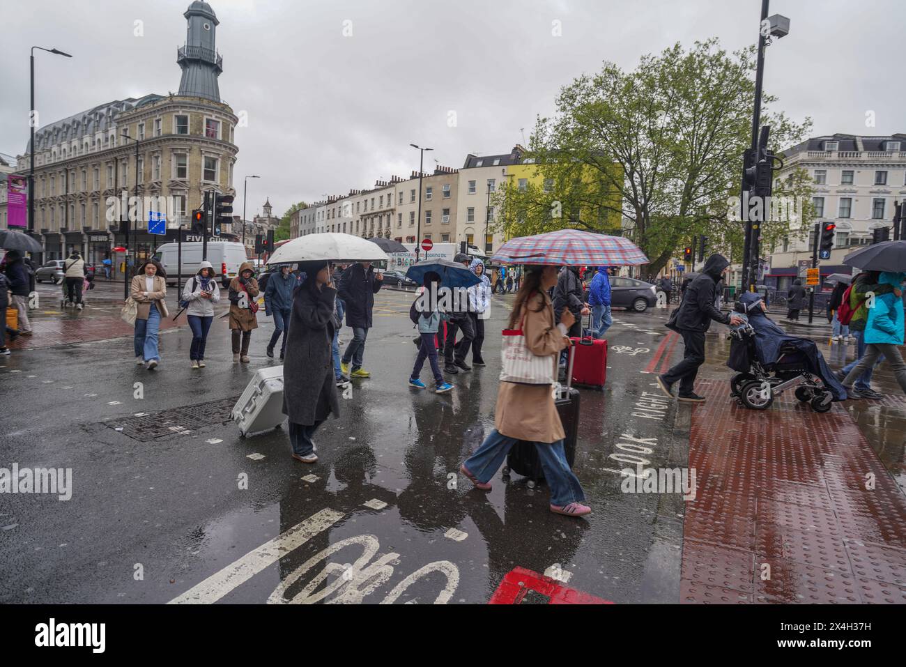 London, Großbritannien. 3. Mai 2024. Fußgänger im Kings Cross, die bei Regenwetter mit Sonnenschirmen umhüllen. Das Met-Büro hat ein ungeklärtes Feiertagswochenende im Mai prognostiziert. Quelle: amer Gazzal/Alamy Live News Stockfoto