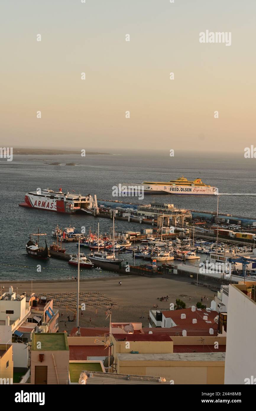 Blick auf einen belebten Hafen mit Fähren und Booten, bei Sonnenuntergang unter klarem Himmel, der die ruhige und dennoch aktive maritime Atmosphäre widerspiegelt Stockfoto