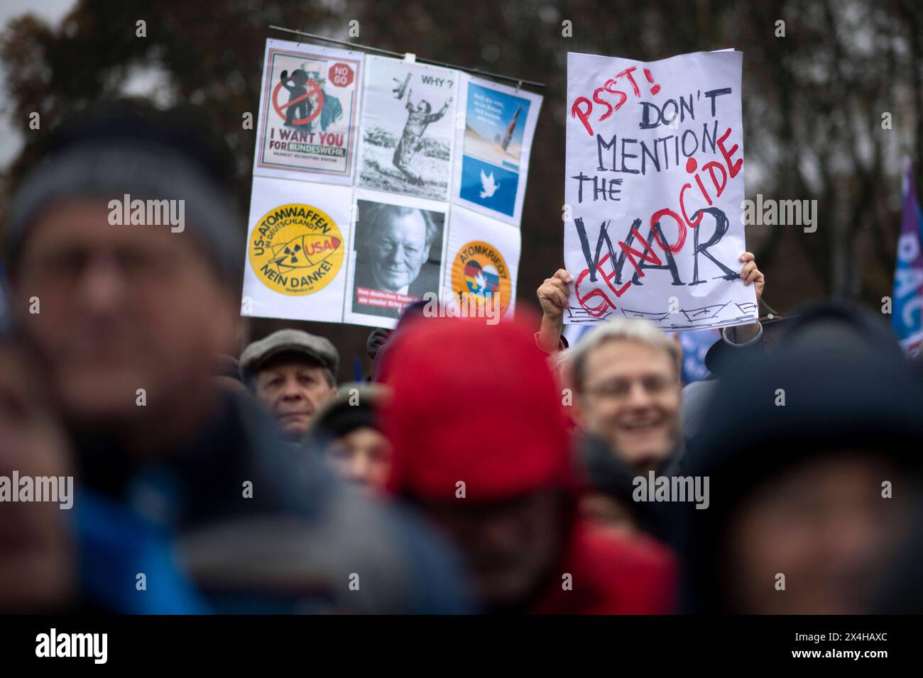 Friedensdemo Nein zu Kriegen DEU, Deutschland, Deutschland, Berlin, 25.11.2023 Demonstranten mit Schild den Völkermordkrieg in Gaza nicht erwähnen Erwaehnen Sie nicht den Völkermordkrieg durch Israel und Plakten mit Foto Willy Brandt auf der Demonstration der deutschen Friedensbewegung unter dem Motto Nein zu Kriegen Ruestungswahnsinn stoppen Zukunft friedlich und gerecht gestalten die Waffen nider für Frieden und eine soziale Friedenspolitik am Brandenburger Tor in Berlin Deutschland. Der Protest fordert einen Waffenstillstand in Gaza , Friedensverhandlungen und Ende der Sanktionen gegen Russland Stockfoto