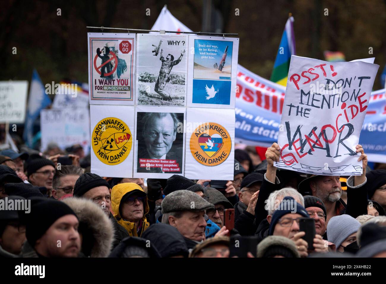 Friedensdemo Nein zu Kriegen DEU, Deutschland, Deutschland, Berlin, 25.11.2023 Demonstranten mit Schild den Völkermordkrieg in Gaza nicht erwähnen Erwaehnen Sie nicht den Völkermordkrieg durch Israel und Plakten mit Foto Willy Brandt auf der Demonstration der deutschen Friedensbewegung unter dem Motto Nein zu Kriegen Ruestungswahnsinn stoppen Zukunft friedlich und gerecht gestalten die Waffen nider für Frieden und eine soziale Friedenspolitik am Brandenburger Tor in Berlin Deutschland. Der Protest fordert einen Waffenstillstand in Gaza , Friedensverhandlungen und Ende der Sanktionen gegen Russland Stockfoto