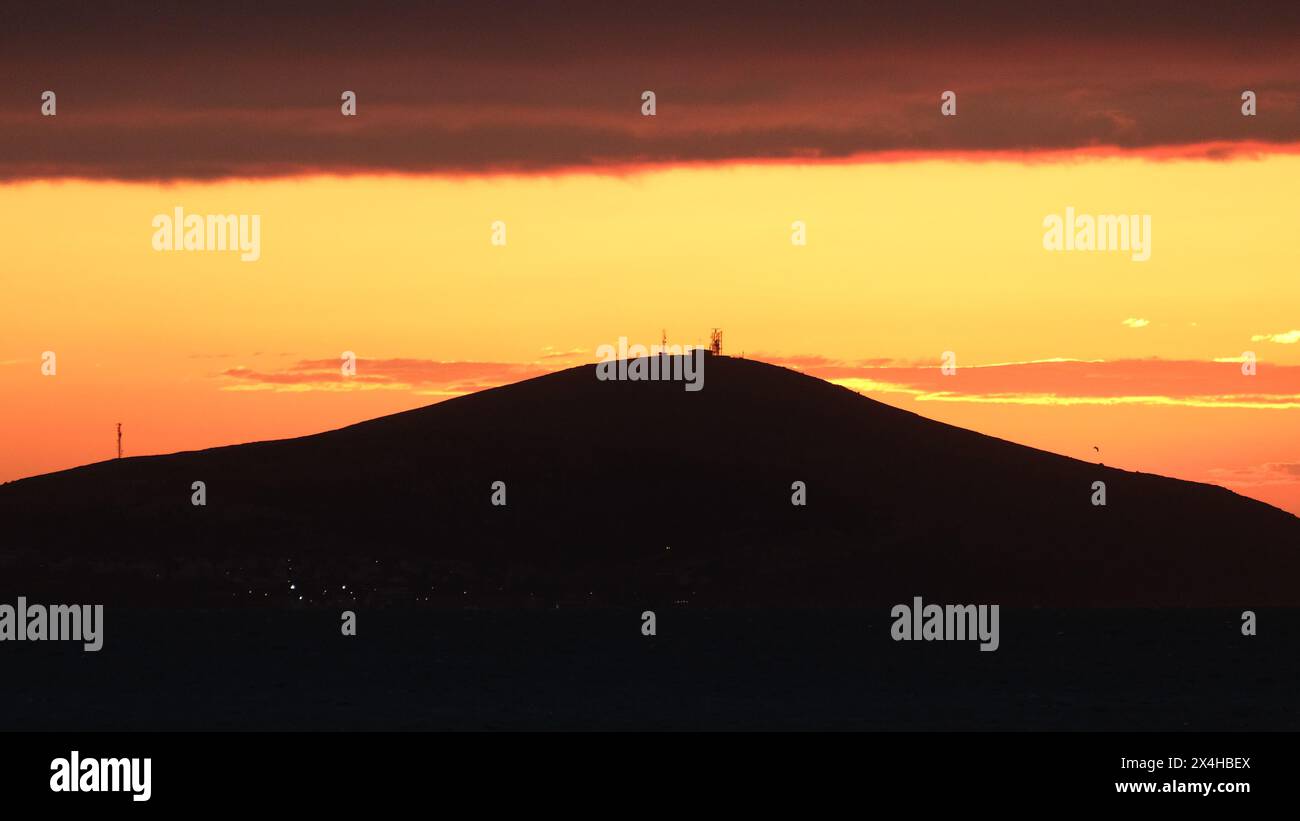 Sonnenuntergang von Bozcaada auf der Ägäischen Insel aus dem Viertel Geyikli in der Stadt Canakkale. Goldene Stunden mit Meer und Insel in Bozcaada. Stockfoto