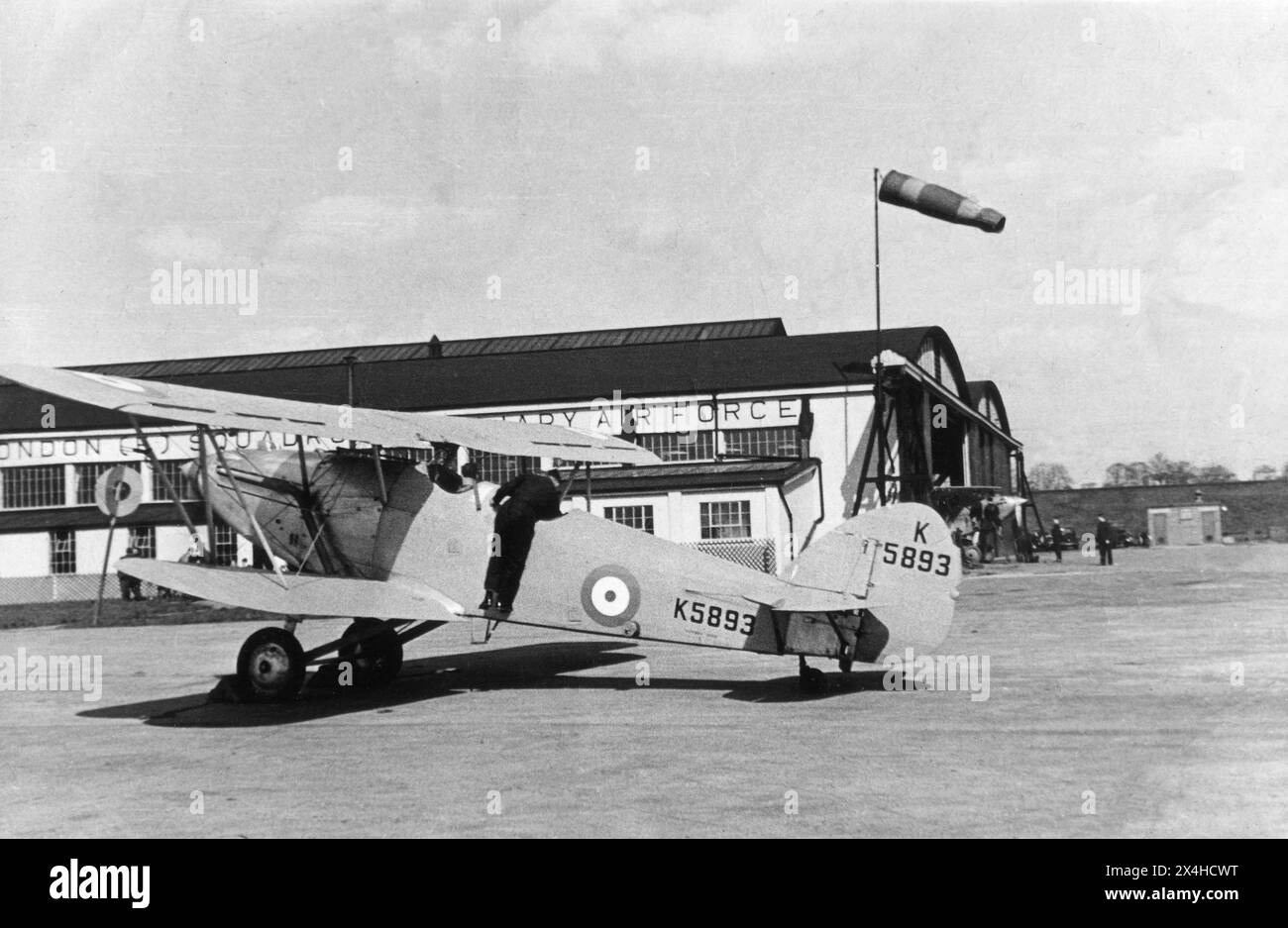 Hendon, London. 1935: Ein Hawker Hart-Trainer-Doppeldecker der 601 (County of London) Squadron, Auxiliary Air Force, parkte vor dem Hangar der Staffel bei der RAF Hendon im Nordwesten Londons. Dieses Flugzeug mit der Zulassungsnummer K5893 wurde von Vickers gebaut und mit einem Rolls Royce Kestrel X-Triebwerk ausgestattet. No. 601 Squadron war eine Reserve-Geschwader der Royal Air Force, die im Oktober 1925 bei der RAF Northolt von einer Gruppe wohlhabender junger aristokratischer Männer gebildet wurde, die auch Amateurflieger waren. Das Geschwader erhielt den Spitznamen „The Millionaires Squadron“. Stockfoto