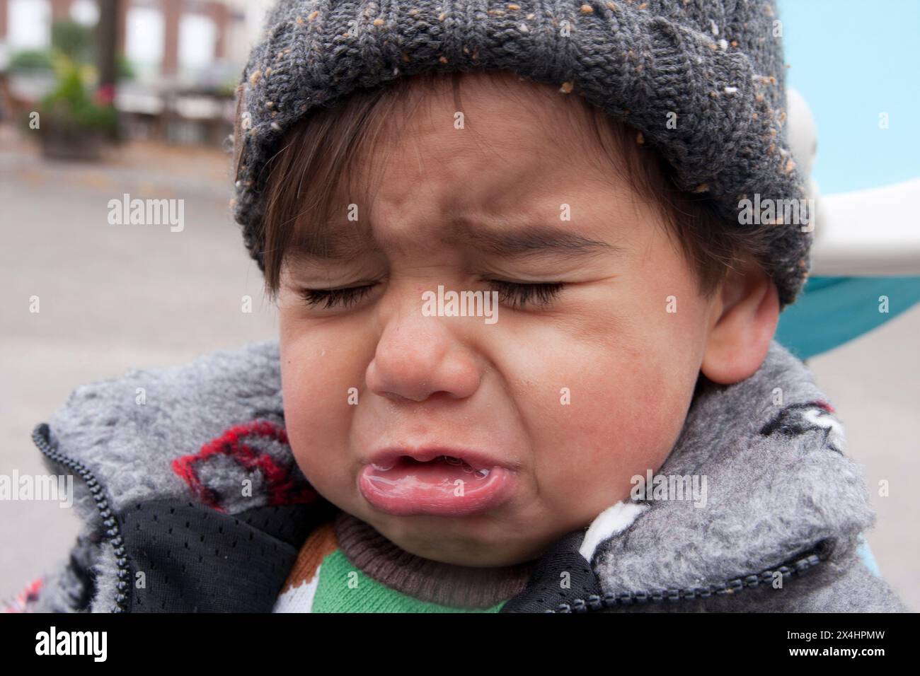 Kleinkind mit Wollmütze weinend, Wutanfall wirft Stockfoto