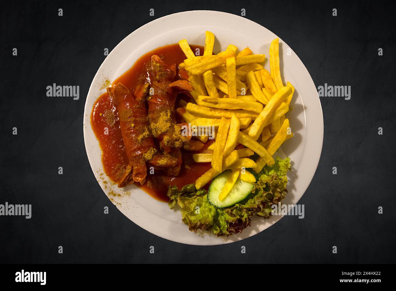 Currywurst mit Pommes frites auf dunklem Hintergrund, Franken, Bayern, Deutschland Stockfoto