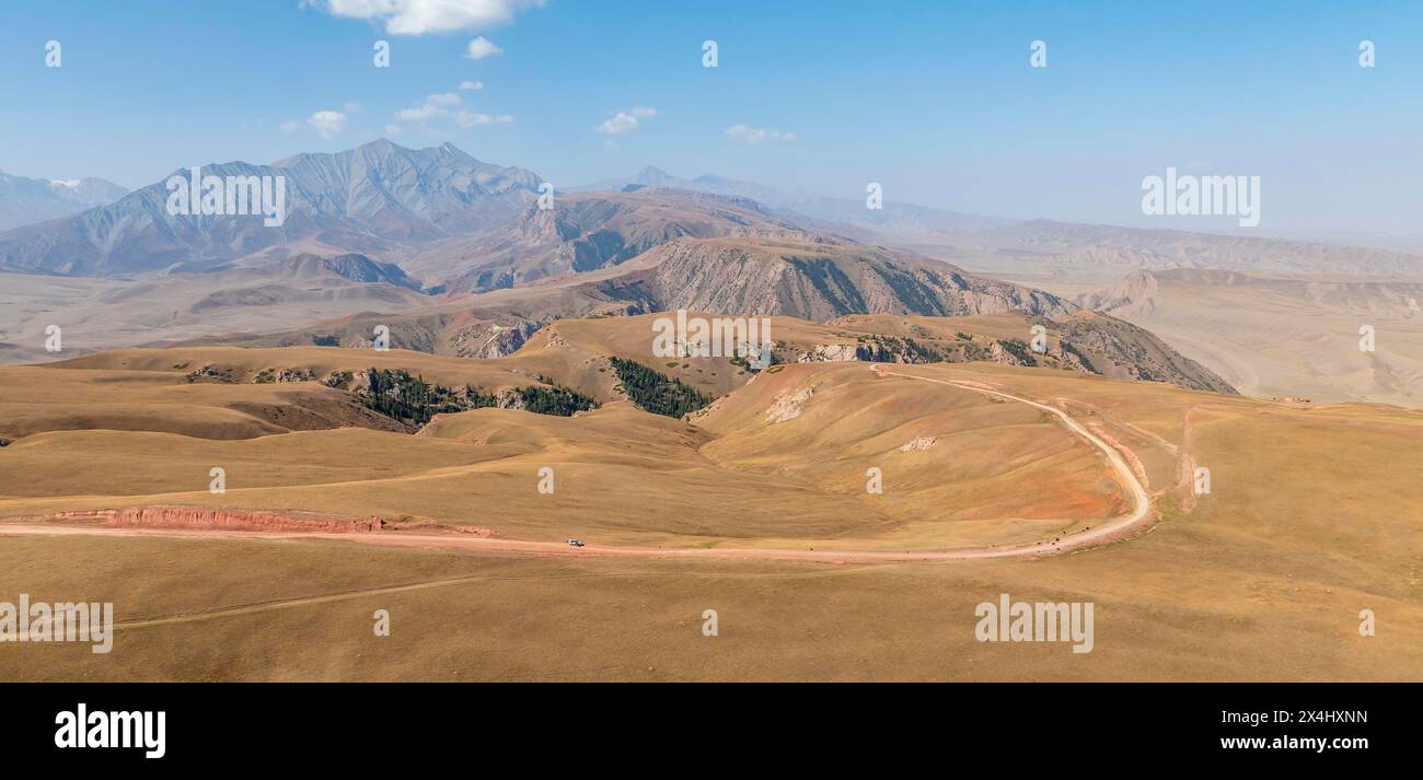 Berglandschaft mit steilen Felsen, erodierten Felsformationen zwischen gelben Hügeln, in der Nähe von Baetov, Naryn Region, Kirgisistan Stockfoto