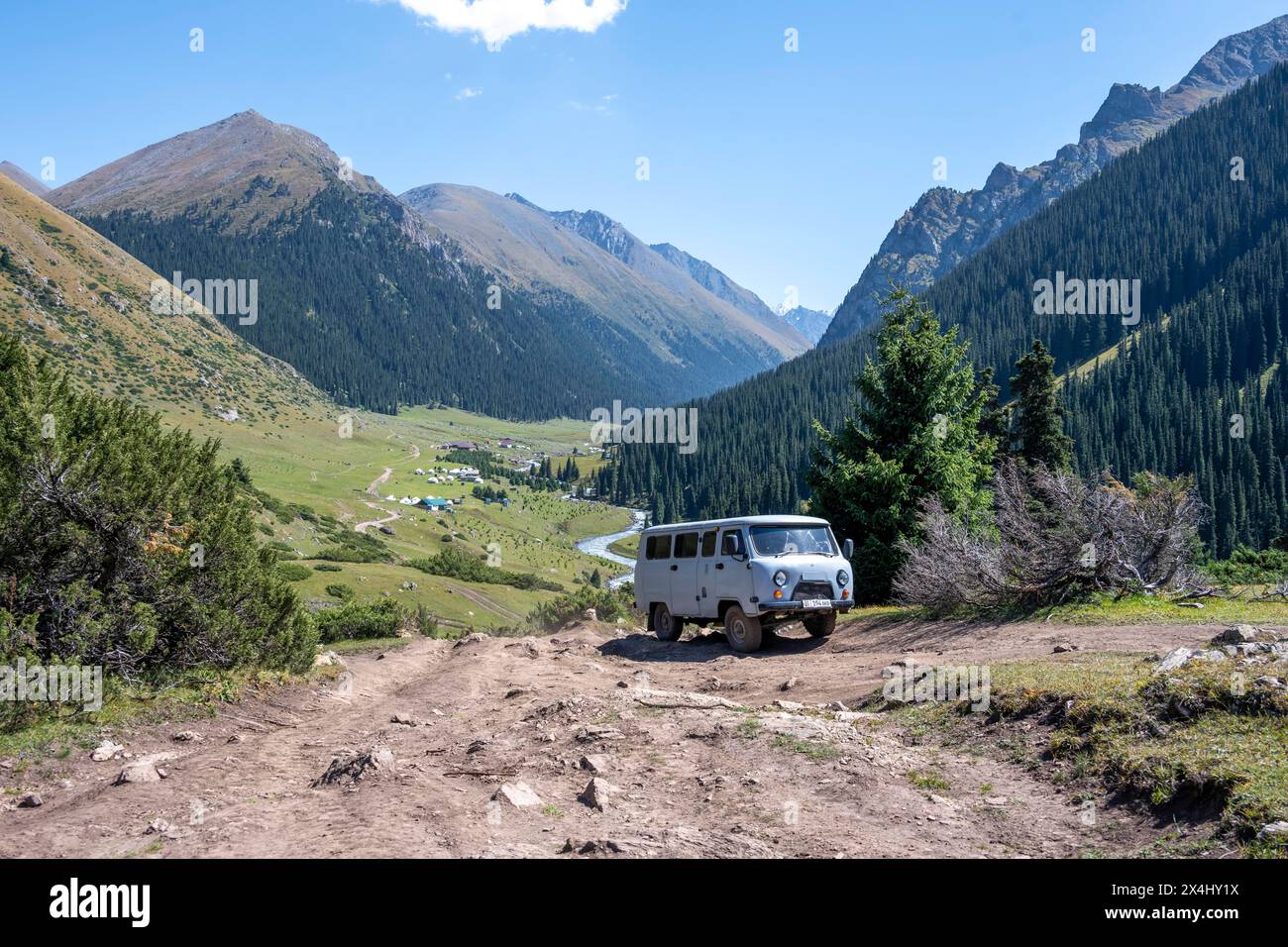 UAZ Buchanka, russisches Geländefahrzeug auf Geländewagen, grünes Bergtal mit Dorf Altyn Arashan, Tien Shan Berge, Kirgisistan Stockfoto