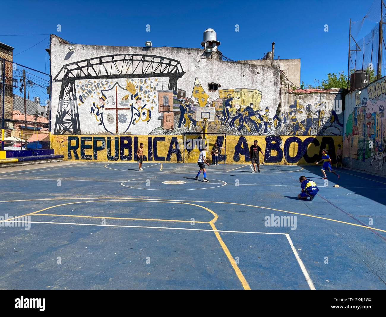 Kinder spielen Fußball auf einem Sportplatz im Viertel La Boca in der Nähe des Fußballclubs Boca Juniors in Buenos Aires, Argentinien Stockfoto