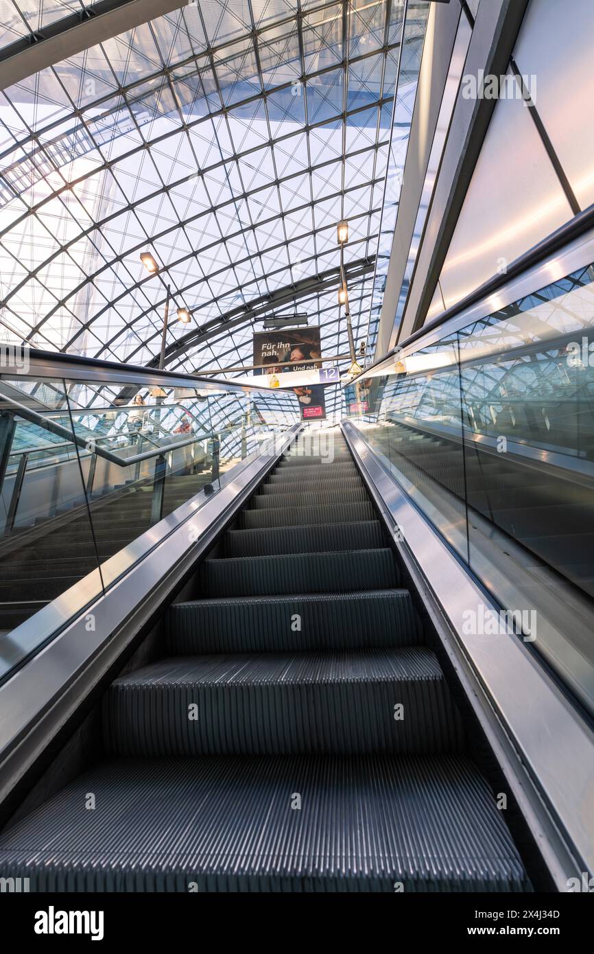 Eine Rolltreppe führt in eine moderne Bahnhofshalle mit einem beeindruckenden Glasdach, Berlin, Deutschland Stockfoto