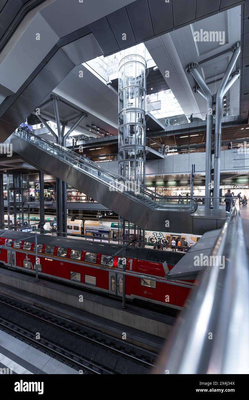 Moderne Bahnhofshalle mit Glasdetails und einem roten Zug im Hintergrund, Berlin, Berlin Hauptbahnhof, Deutschland Stockfoto