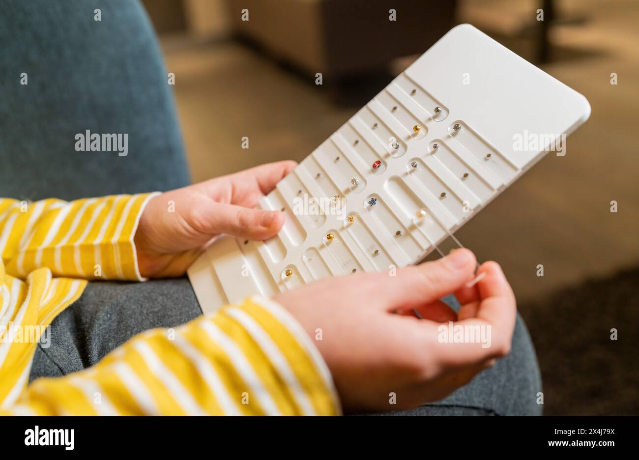 Nahaufnahme einer Kinderhand mit Ohrring-Display in einem Juweliergeschäft im Hintergrund Stockfoto