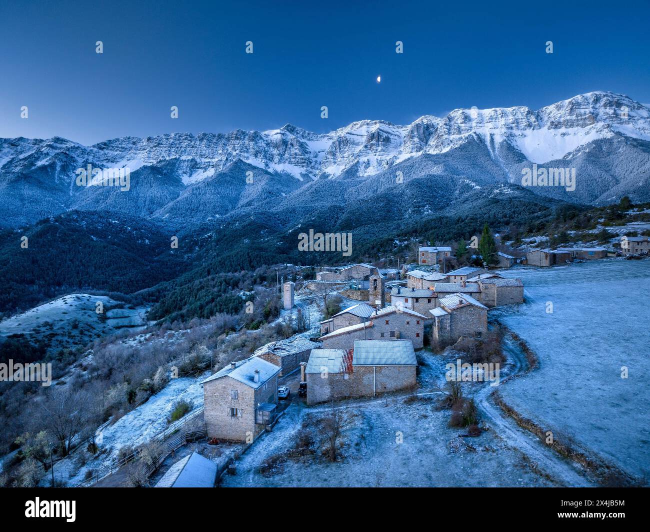 Aus der Vogelperspektive des Dorfes Estana und der schneebedeckten Serra del Cadí vor Sonnenaufgang (Cerdanya, Katalonien, Spanien, Pyrenäen) Stockfoto