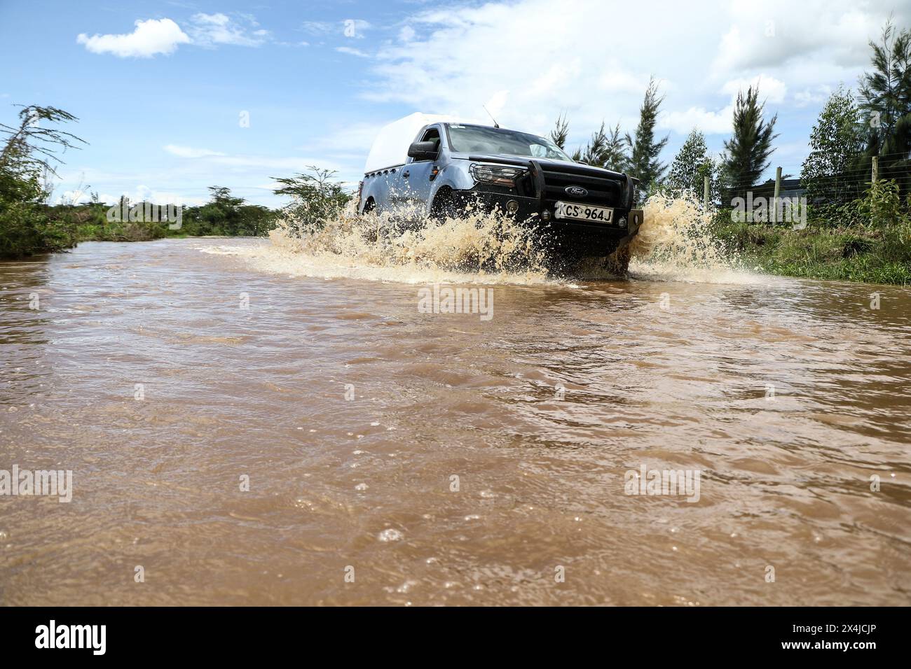 Ein Fahrzeug fährt an einem überfluteten Fluss Rongai im Nakuru County vorbei, nachdem die Regenfälle, die über 200 Menschen das Leben forderten und eine Menge Eigentum in Kenia zerstörten, zunahmen. Präsident William Ruto wies heute während einer Ansprache im State House in Nairobi das Innenministerium an, eine obligatorische Evakuierungsmeldung vom 2,2023. April durchzusetzen, um die Auswirkungen der Überschwemmungen im ganzen Land zu mildern. Stockfoto