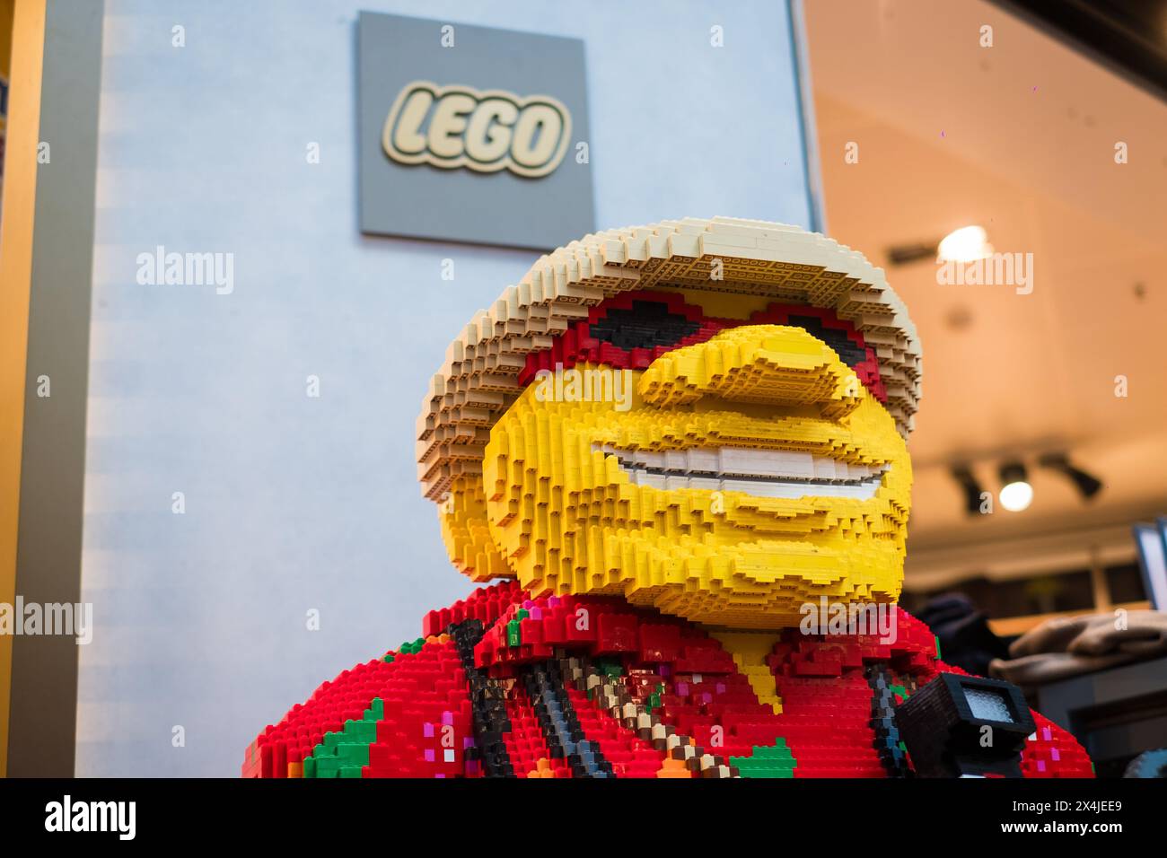 Kopenhagen, Dänemark - 7. April 2024: Riesige Lego-Skulptur eines lächelnden Mannes im Lego-Shop am Flughafen Kopenhagen. Stockfoto