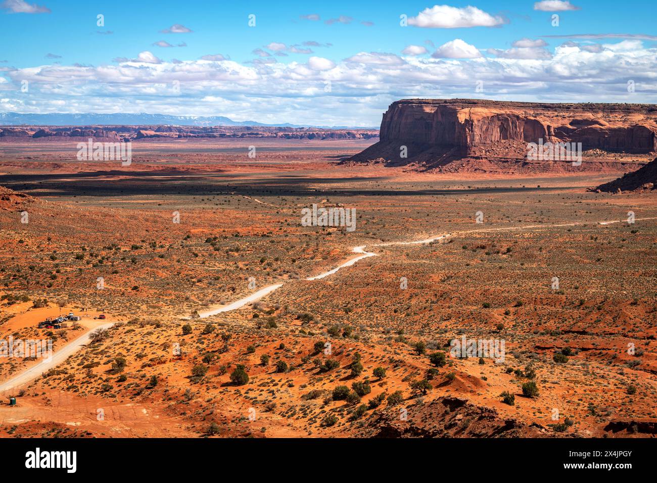 Der Blick auf die lange unbefestigte Straße in den Navajo Tribal Park im Monumant Valley zeigt den anfänglich kargen Blick des Parks, der sich schnell in ein Felsformat verwandelt Stockfoto
