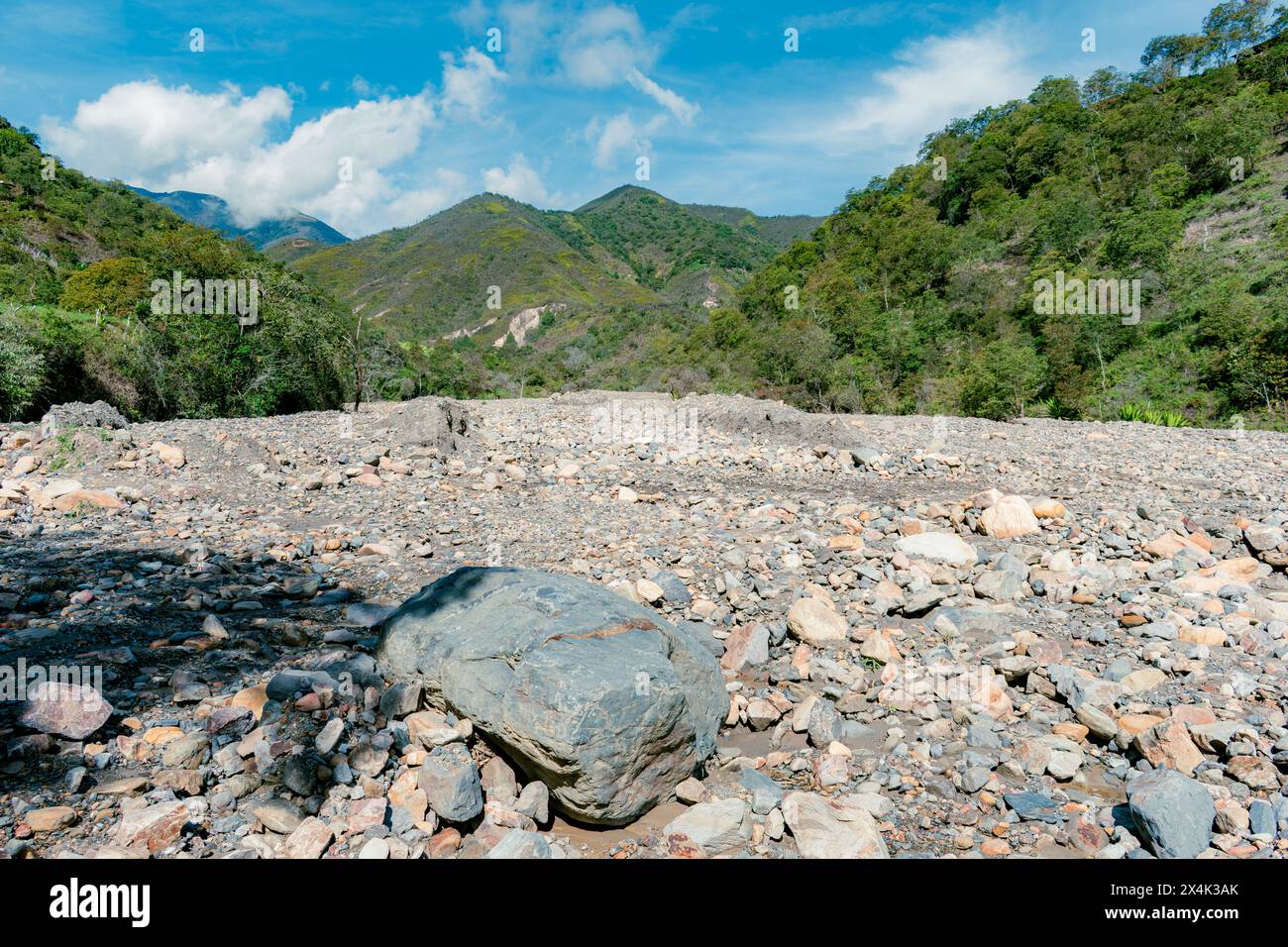 Berglandschaft mit einem Fluss aus Steinen, der aus einer Lawine und dem starken Sommer resultierte, der den Fluss trocken ließ Stockfoto