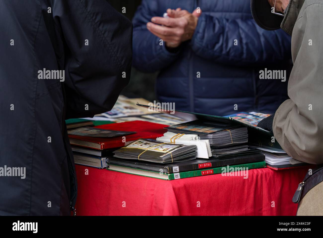 Madrid, Spanien. 11. Februar 2024 - Gruppe von Personen studiert das Sortiment an Sammlerbriefmarken. Stockfoto