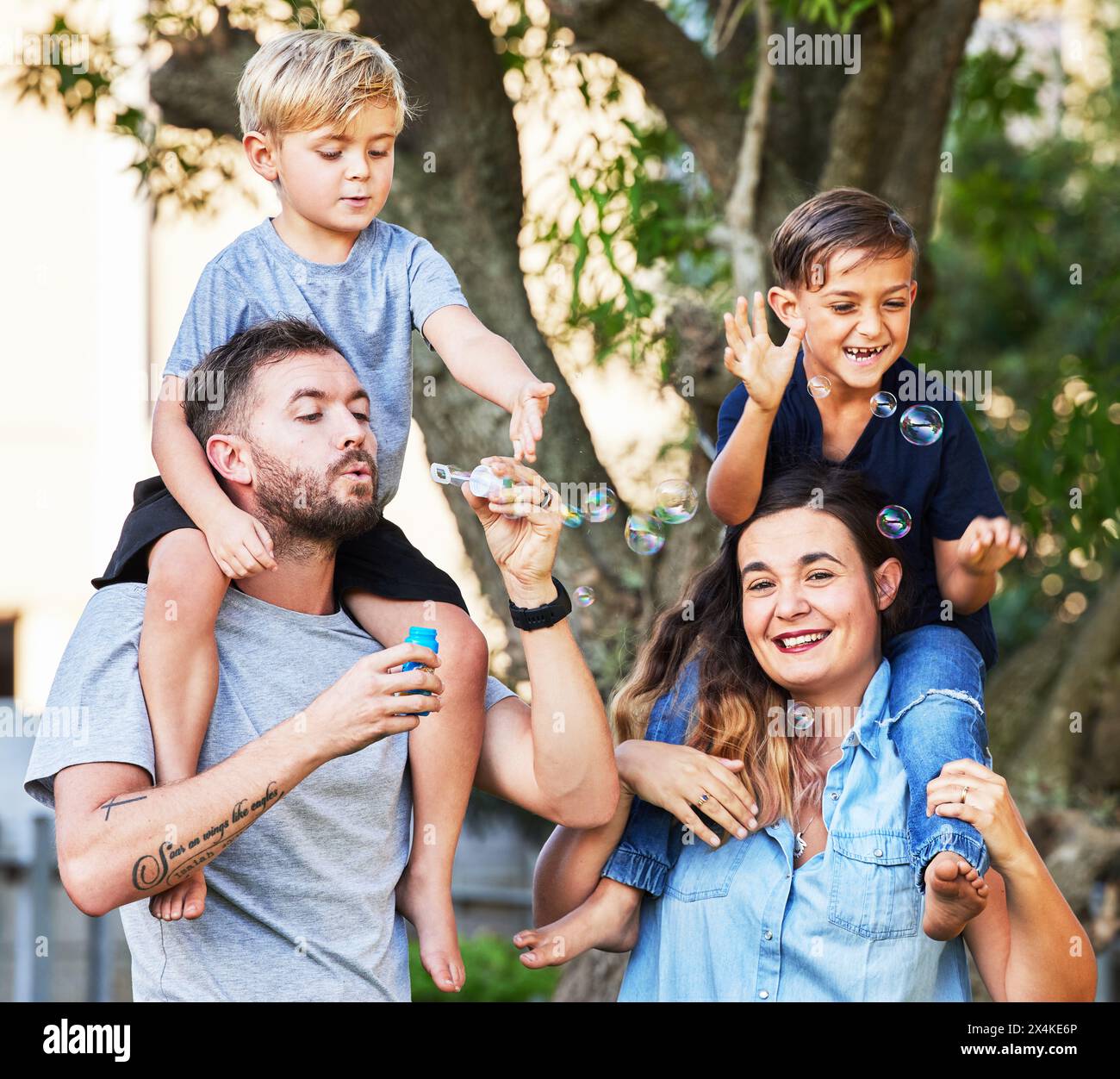 Paare, Kinder und lieben es mit Blasen im Park für eine glückliche Beziehung, Lernen und Familienzeit. Eltern, Kinder und Porträt im Freien zum Entspannen Stockfoto