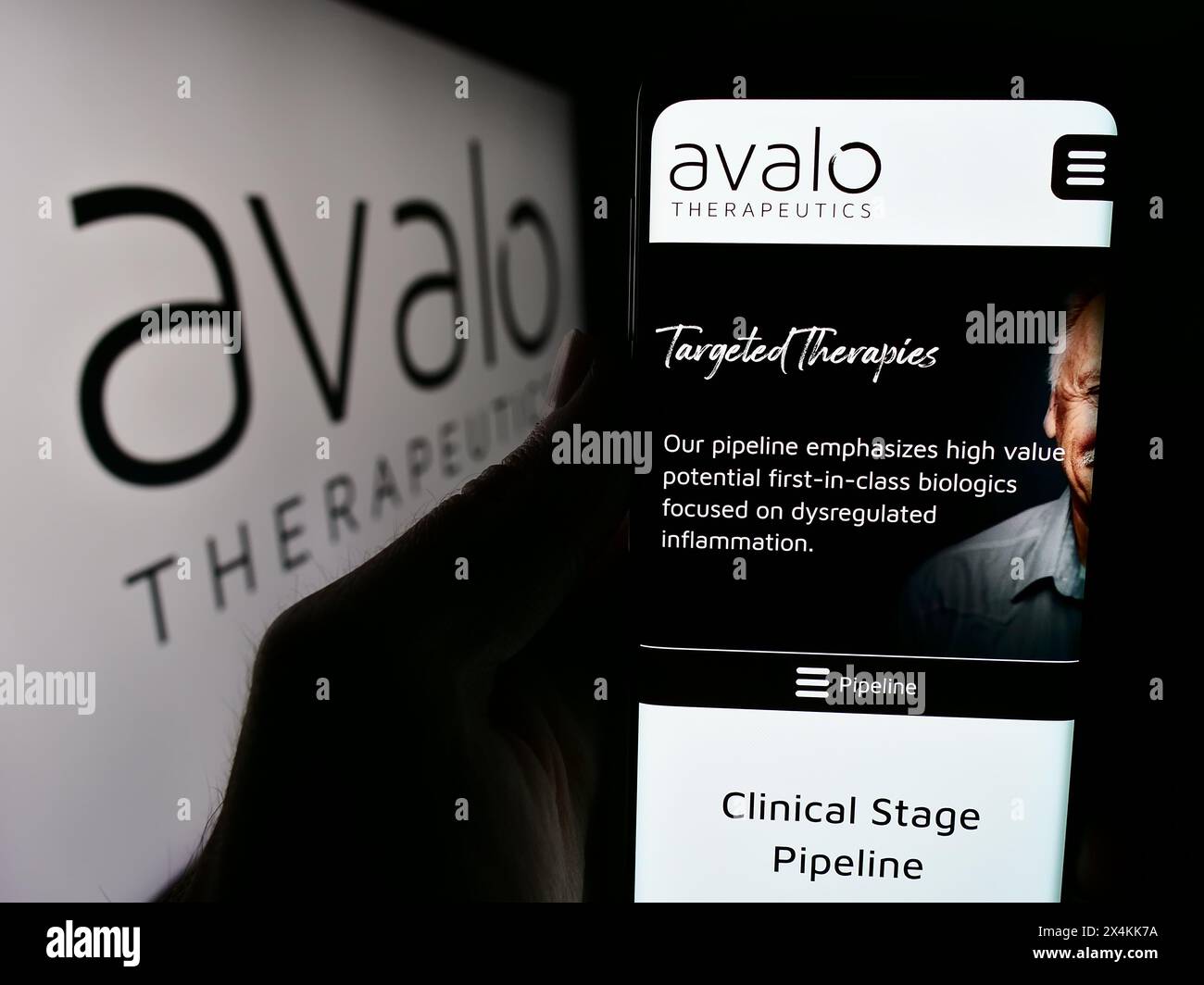 Person, die ein Mobiltelefon hält, mit Website des US-amerikanischen Biotechnologie-Unternehmens Avalo Therapeutics Inc. Vor dem Logo. Konzentrieren Sie sich auf die Mitte des Telefondisplays. Stockfoto
