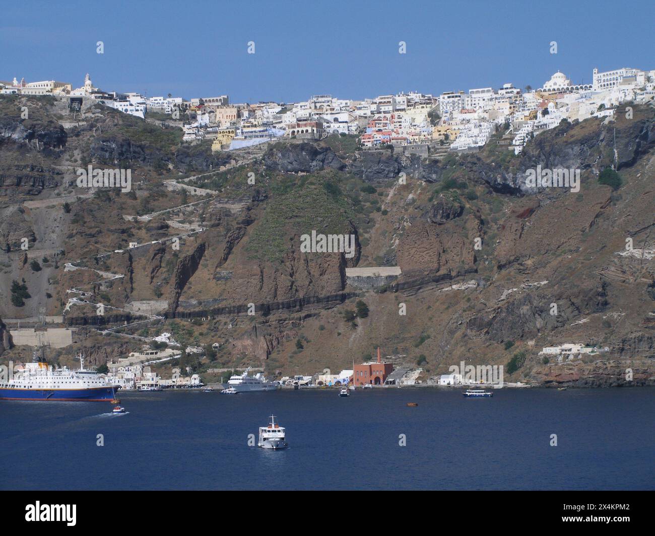 Blick auf die Stadt fira, santorin, griechenland, an einem sonnigen Tag von einem Boot in der ägäis Stockfoto