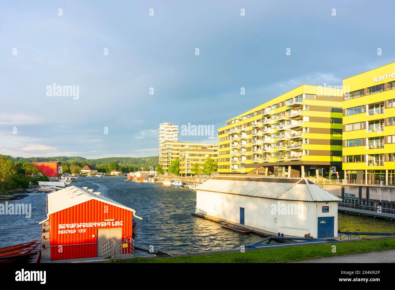 Linz: Hafen Winterhafen, Mehrfamilienhäuser, Bootshäuser der Feuerwehr und Polizei in Donau, Oberösterreich, Österreich Stockfoto