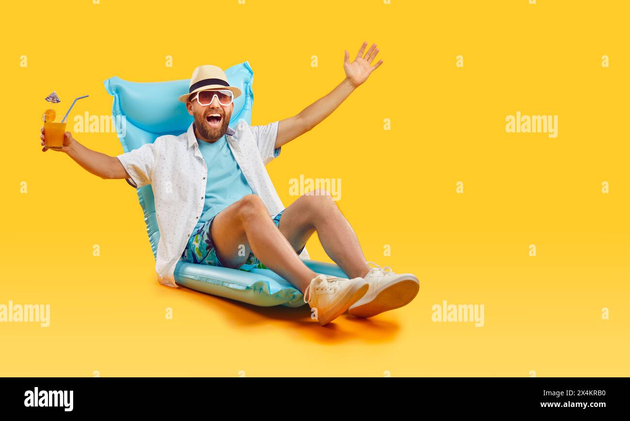 Mann, der sich auf aufblasbarer Matratze mit Cocktail entspannt Stockfoto