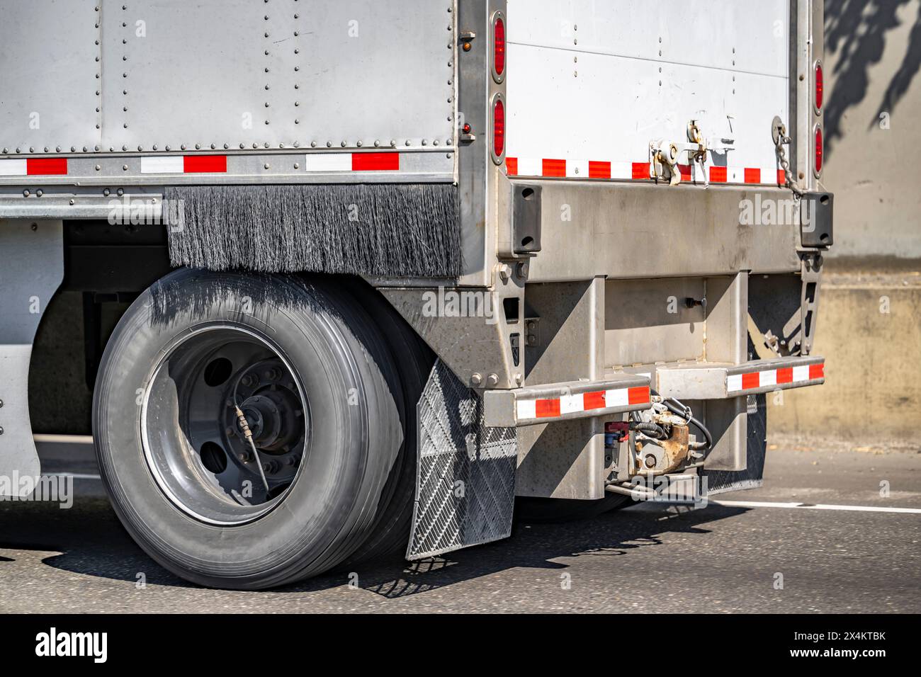 Industrietransportwagen mit großem Lkw für den Transport von gewerblicher Ladung in einem trockenen Auflieger mit Hinterachsrad mit Reifen und automatischem Aufpumpen und Stockfoto