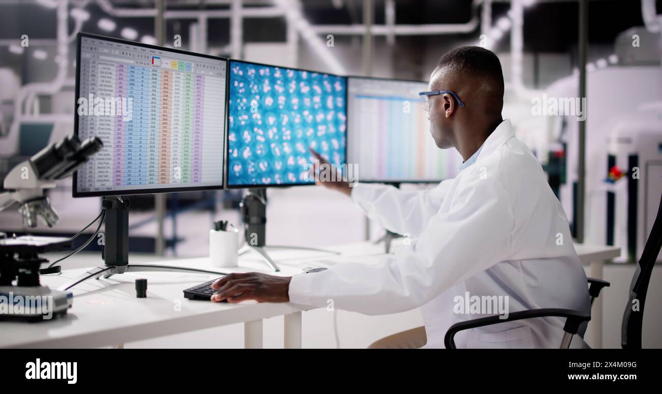 Afroamerikaner Analysiert Tabellenkalkulationsdaten Bei Der Arbeit Stockfoto