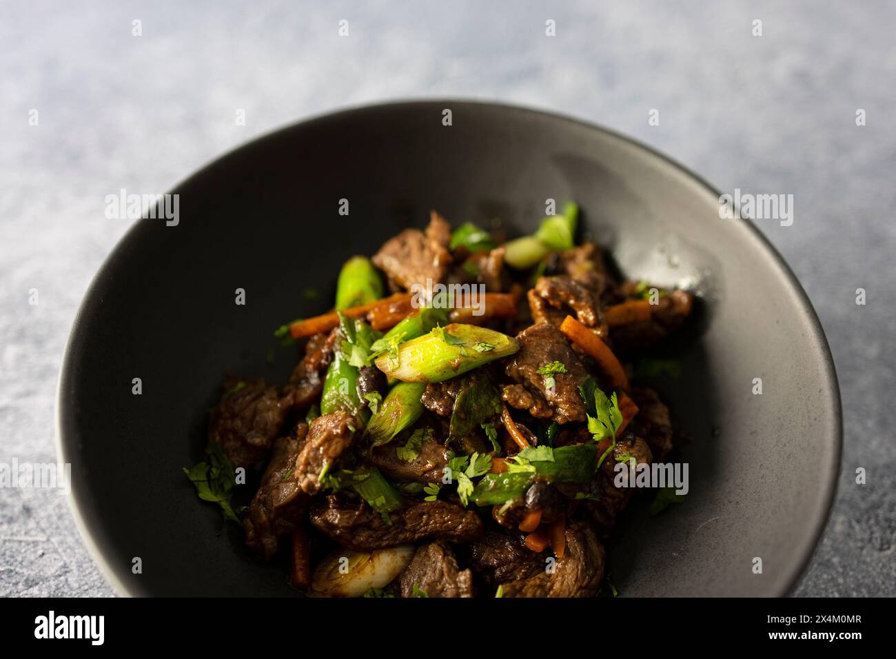 Rindfleisch mit schwarzer Bohnensauce, Karotten und Frühlingszwiebeln Stockfoto