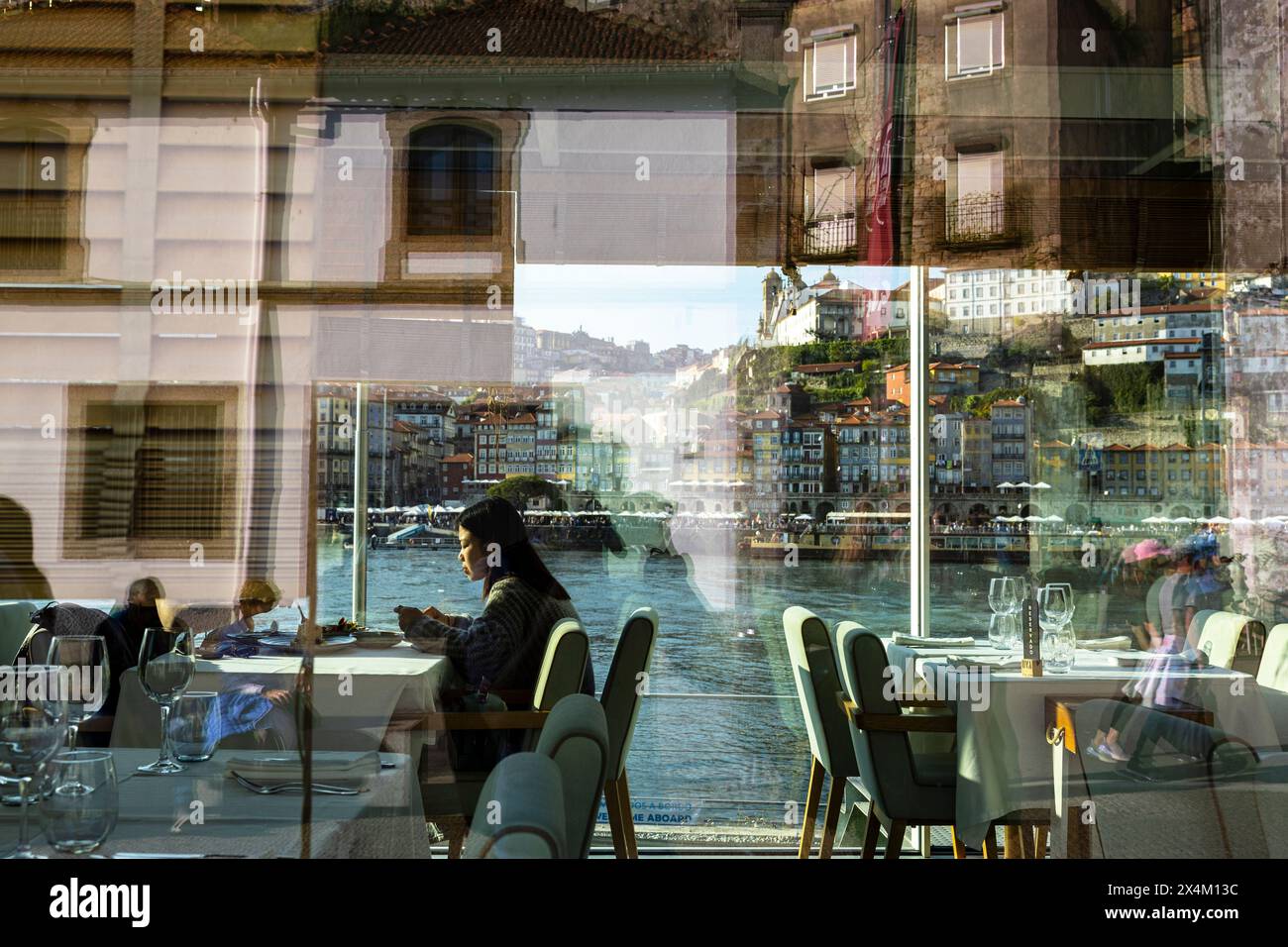 Porto, Portugal - 03. April 2023 : Leute in einem Restaurant mit Blick auf Porto ribeira Stockfoto