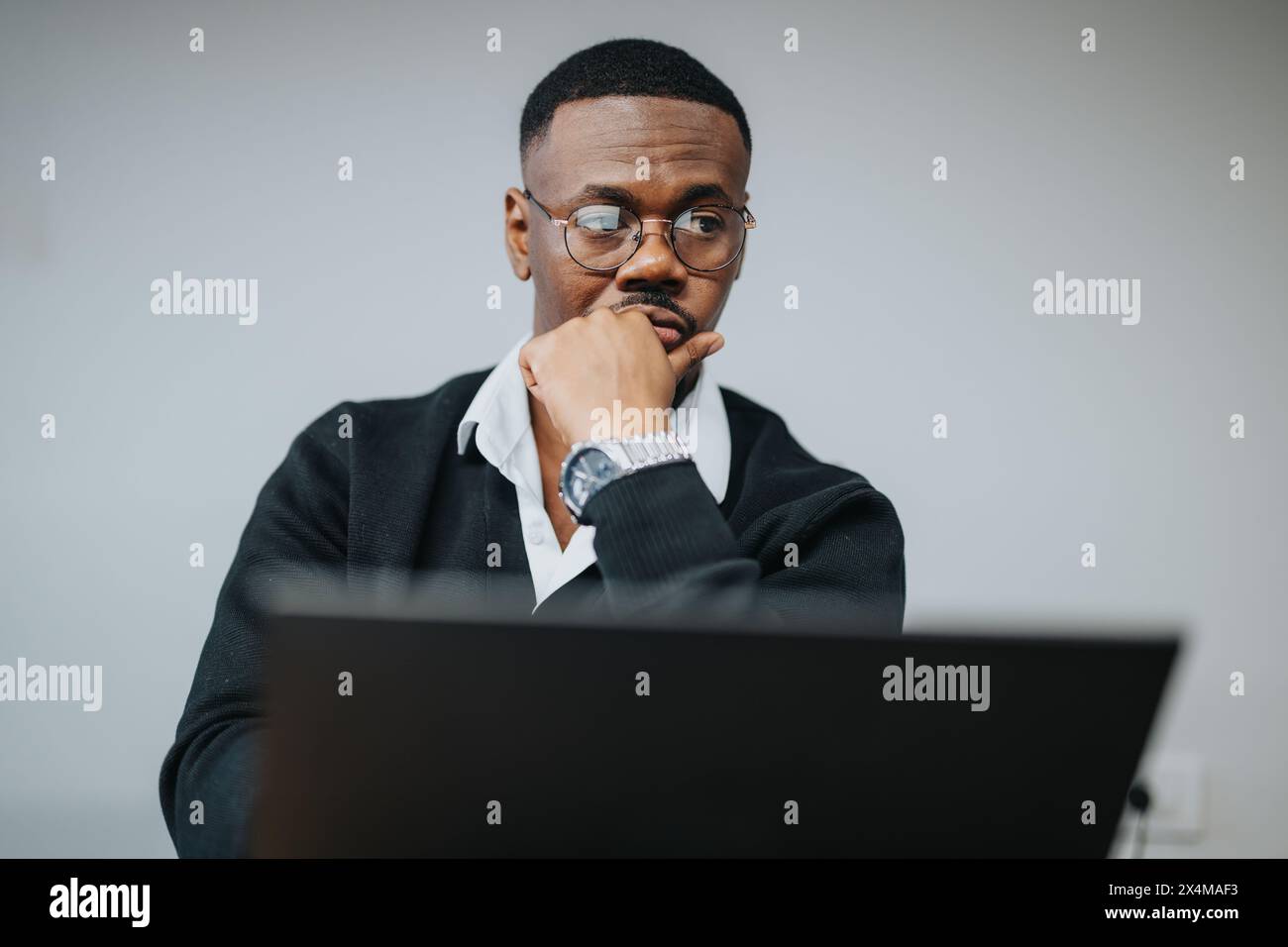 Fokussierter afroamerikanischer Geschäftsmann, der Daten auf einem Computer in einem Büro analysiert Stockfoto