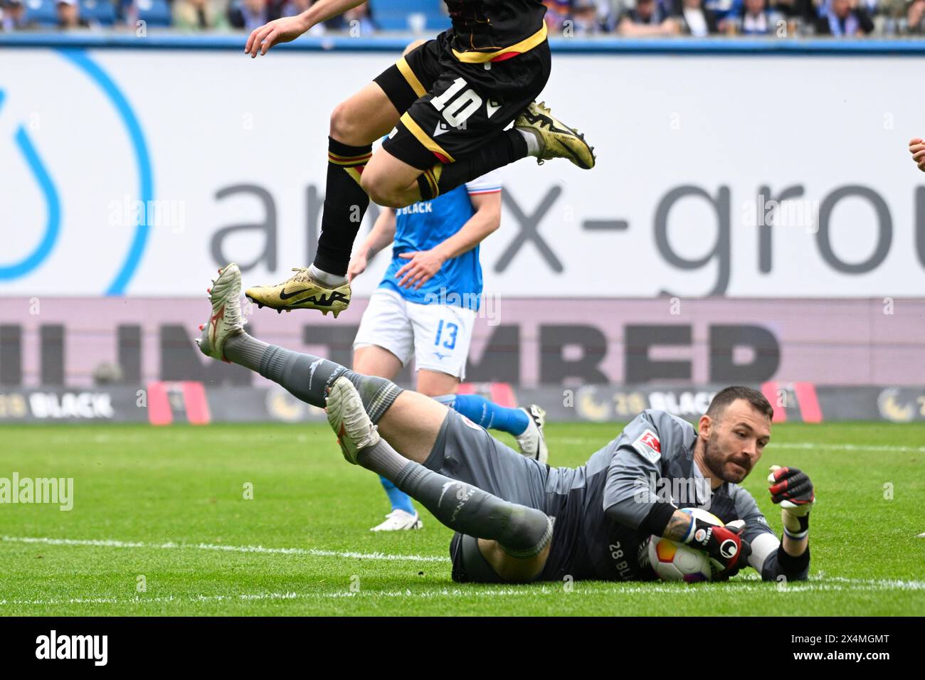 4. Mai 2023, Mecklenburg-Vorpommern, Rostock: Fußball: Bundesliga 2, Hansa Rostock - Karlsruher SC, Spieltag 32, Ostseestadion. Rostocker Torhüter Markus Kolke (r) fängt den Ball von Karlsruher Marvin Wanitzek vor dem Tor ab. Foto: Gregor Fischer/dpa - WICHTIGER HINWEIS: Gemäß den Vorschriften der DFL Deutschen Fußball-Liga und des DFB Deutschen Fußball-Bundes ist es verboten, im Stadion und/oder im Spiel aufgenommene Fotografien in Form von sequenziellen Bildern und/oder videoähnlichen Fotoserien zu verwenden oder zu nutzen. Stockfoto