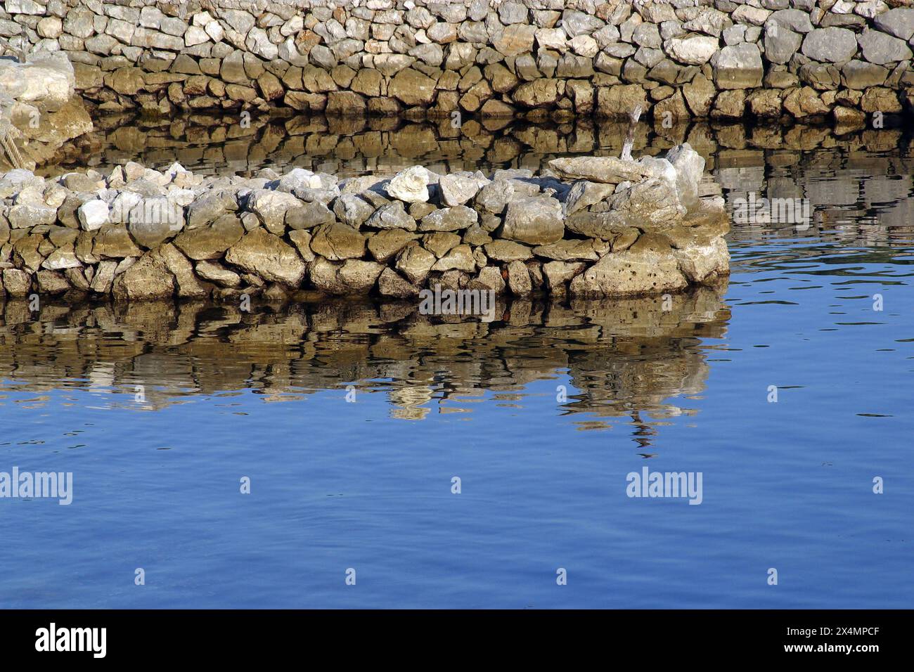 Ein kleiner Steinhafen und Pier in Simuni, Insel Pag, Kroatien Stockfoto