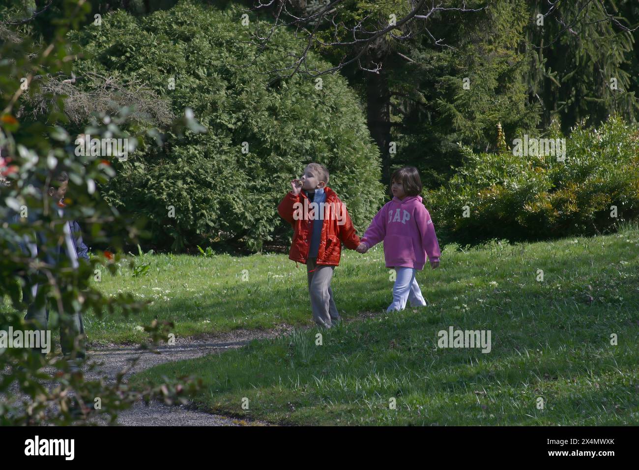 Mädchen und Junge gehen zusammen Hände im Freien in einem Botanischen Garten in Zagreb, Kroatien Stockfoto
